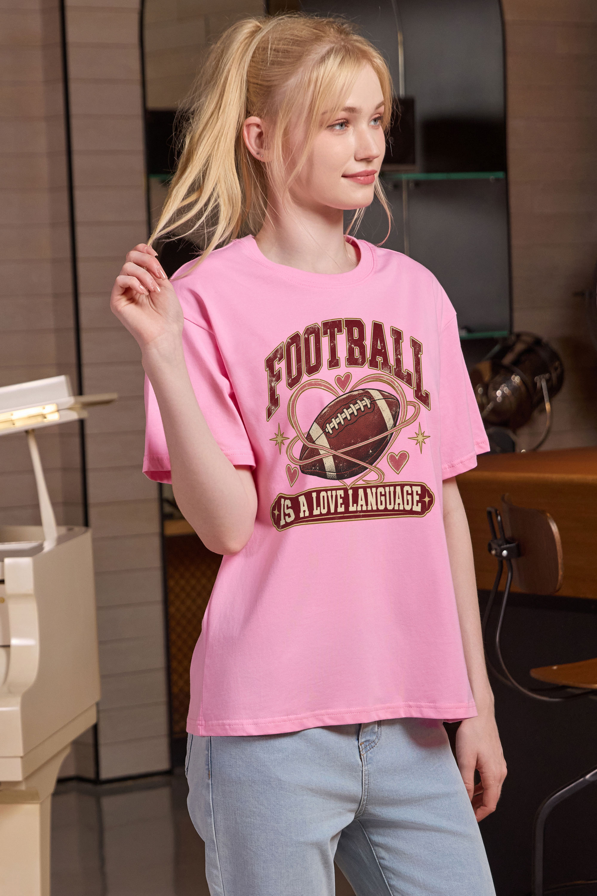 Football Is a Love Language Relaxed Tee in light pink, front graphic on model, view 2